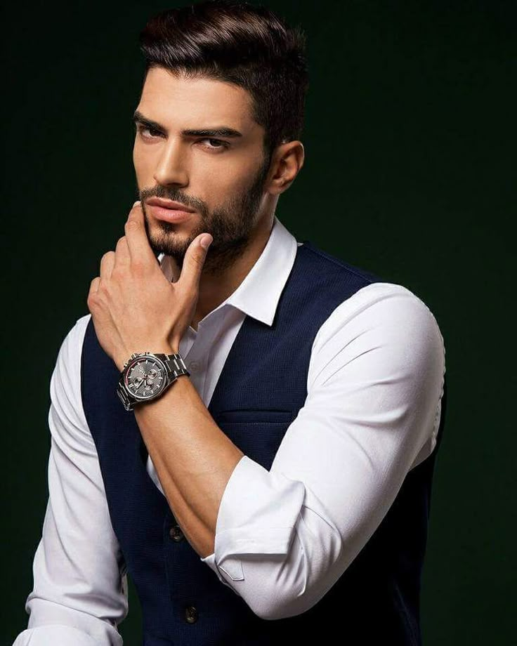 a man with a watch on his left hand is looking at the camera while wearing a vest