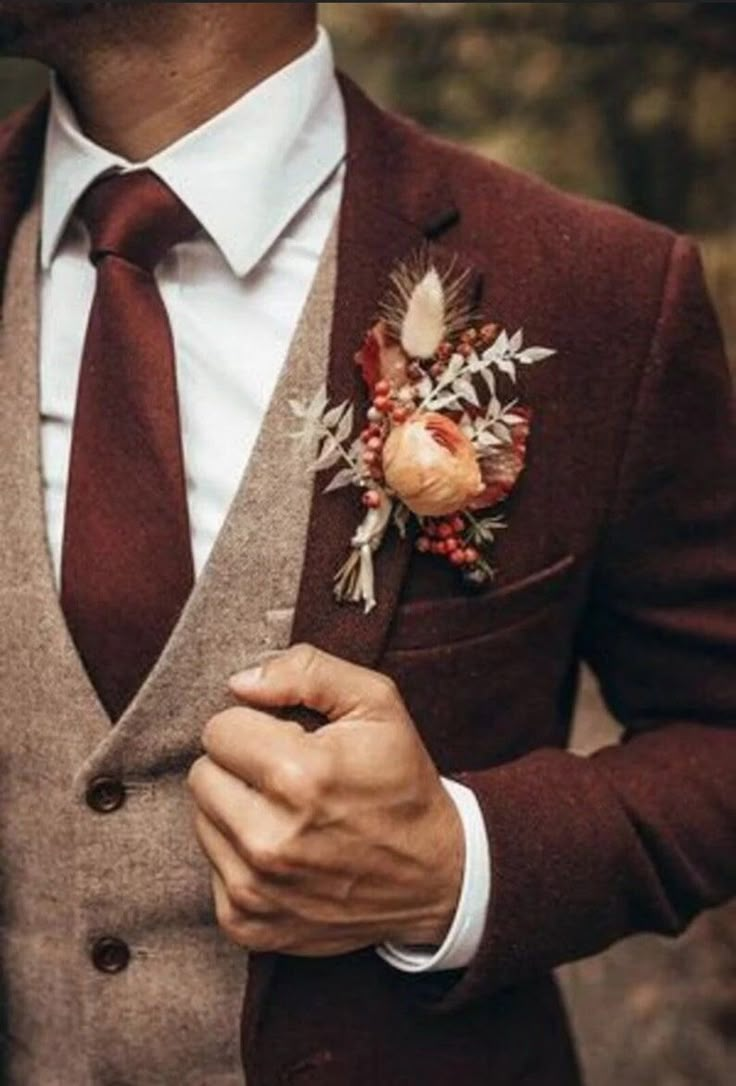 a man in a suit and tie with flowers on his lapel flower boutonniere