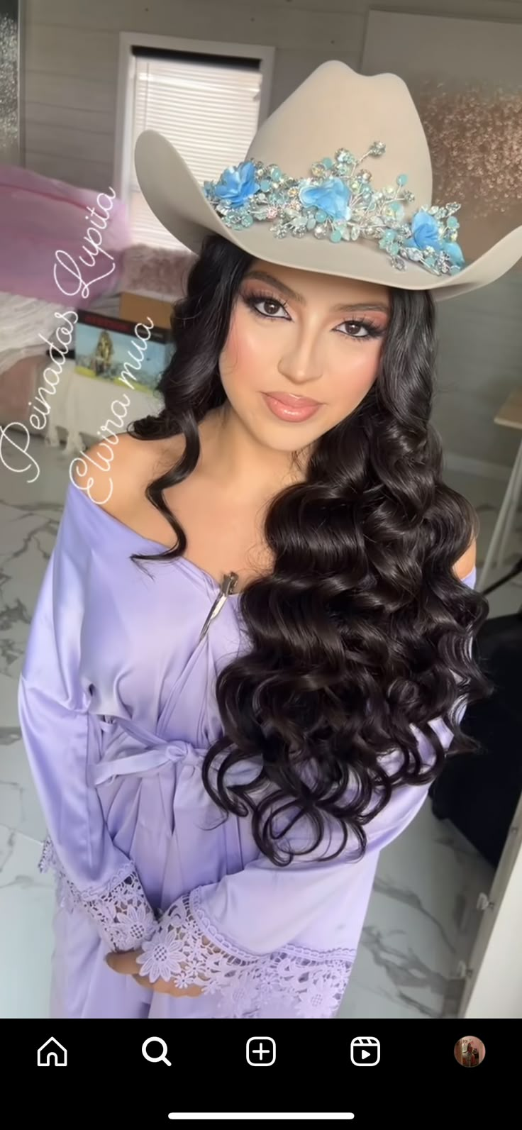 a woman with long hair wearing a cowboy hat and purple dress is looking at the camera