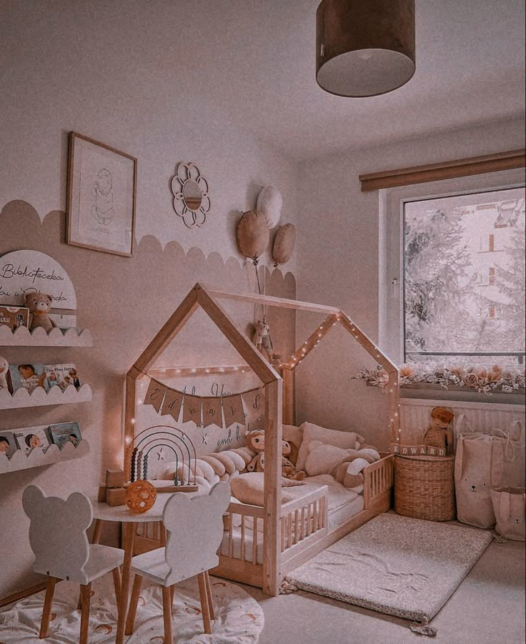 a child's bedroom decorated in pink and white with a wooden doll house bed