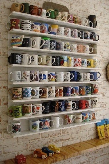 coffee mugs are lined up on the wall