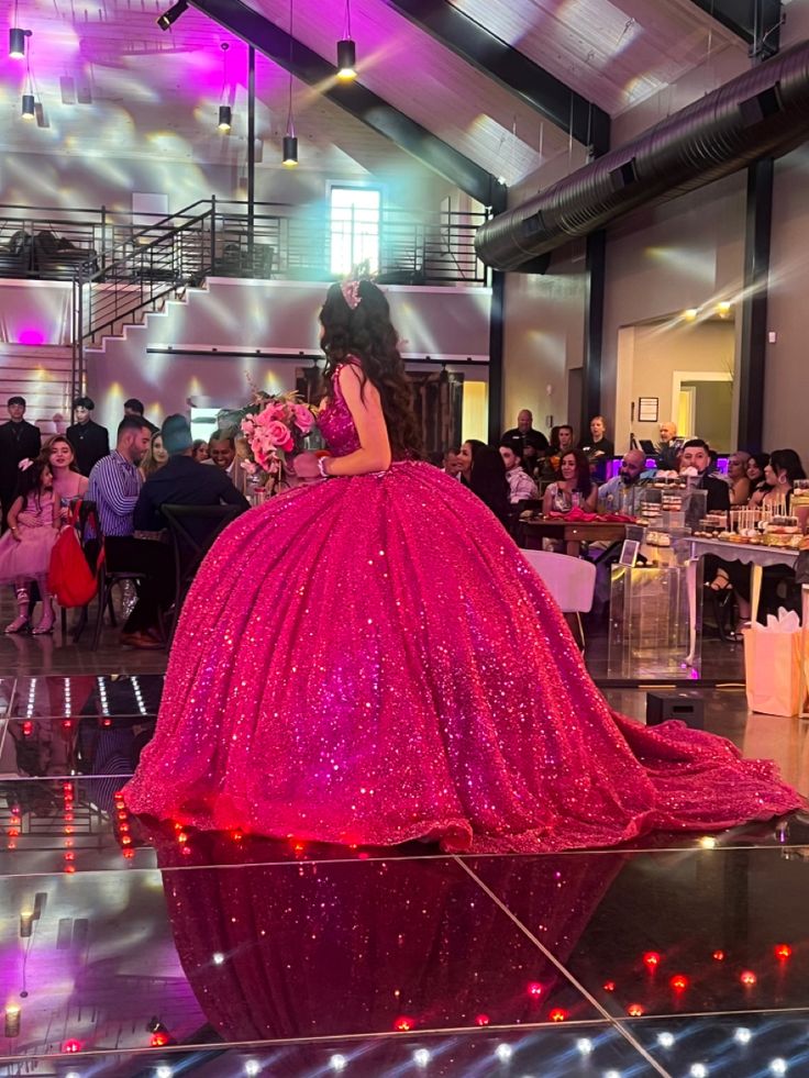 a woman in a pink dress standing on top of a dance floor