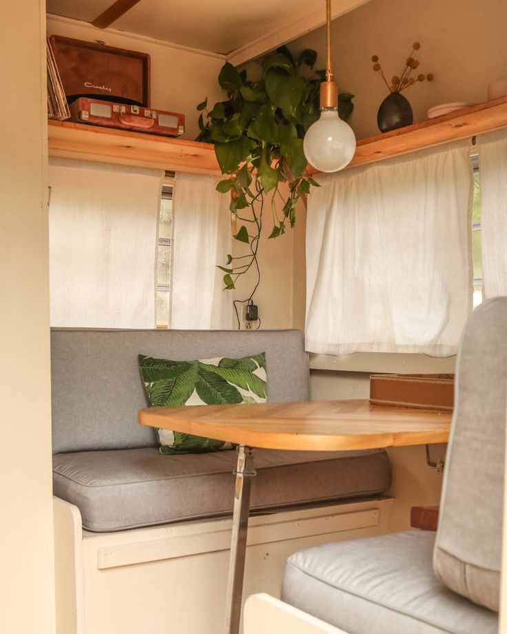 the inside of a camper with a small table and bench in front of it