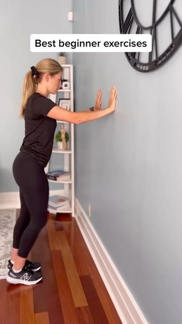 a woman standing in front of a clock on the wall