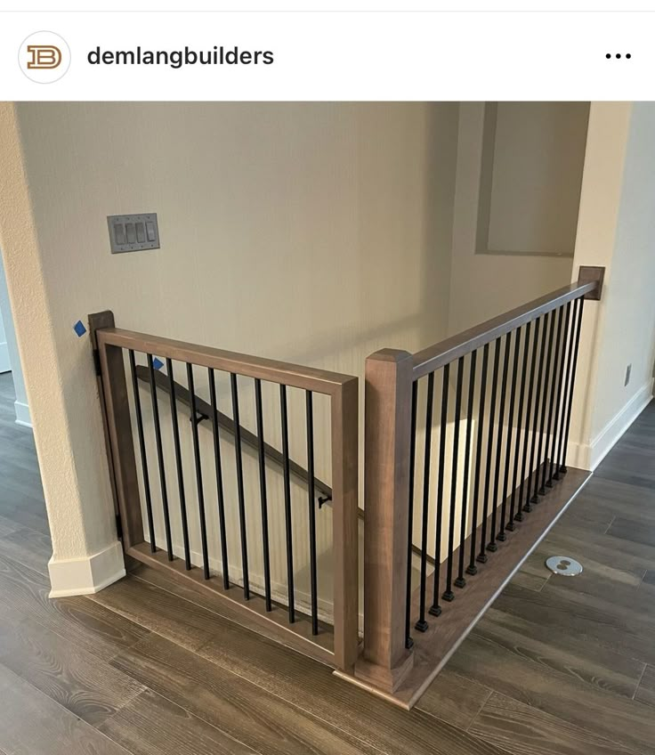 an empty room with wooden railings and hard wood flooring on the bottom level