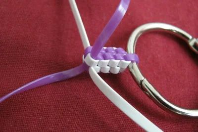 a pair of scissors that are sitting on a red cloth with purple and white ribbon