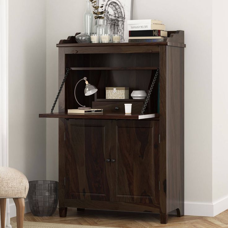 a wooden bookcase sitting on top of a hard wood floor next to a chair