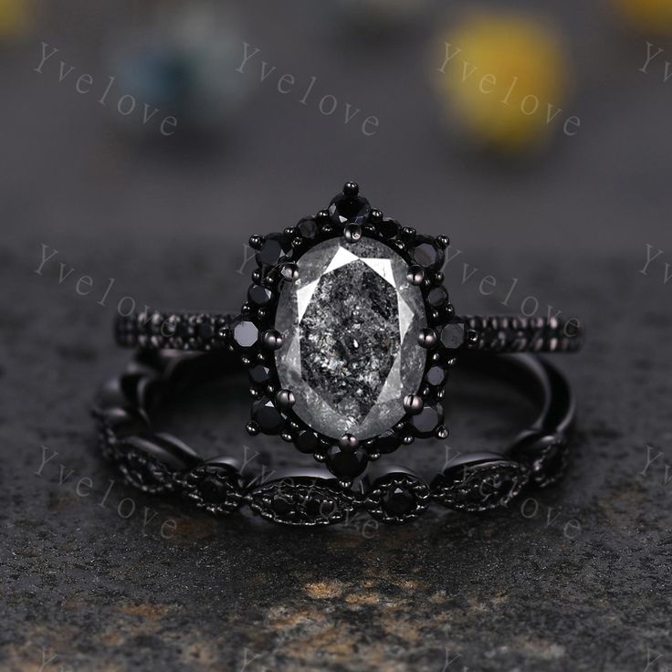 an oval shaped diamond ring set in black gold with diamonds on the band and center stone