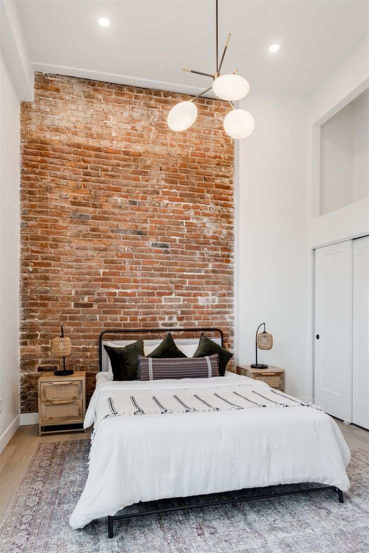 Modern bedroom with modern light fixture and brick feature wall White Exposed Brick Bedroom, Red Brick Bedroom Wall, Brick And Paneling, White Brick Bedroom Ideas, Brick Slips Bedroom, Brick Wallpaper Bedroom Accent Walls, Bedroom With Brick Fireplace, Bedroom Ideas With Brick Wall, Brick Wall Apartment Decor