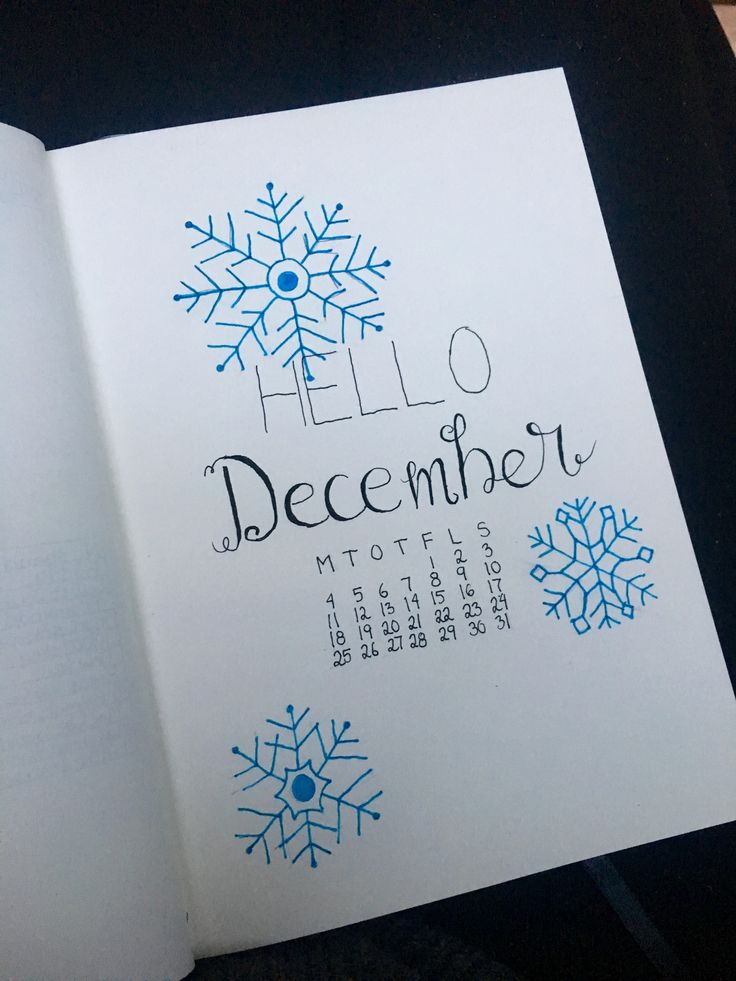 an open book with the words hello december written in blue and white snowflakes