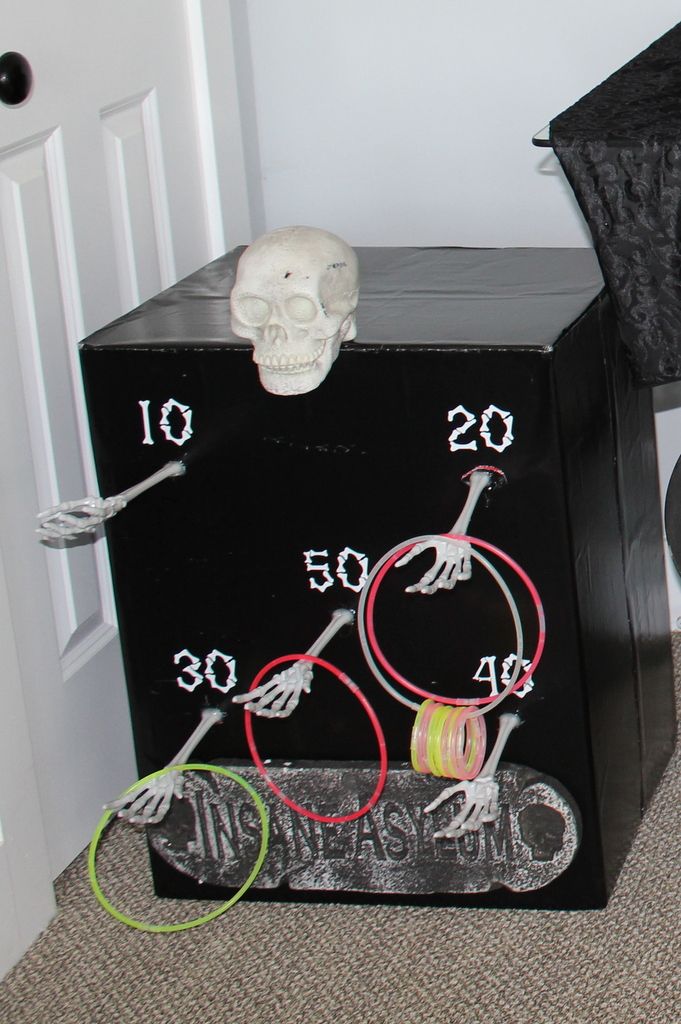 a skeleton is sitting on the floor next to a black box with wires in it