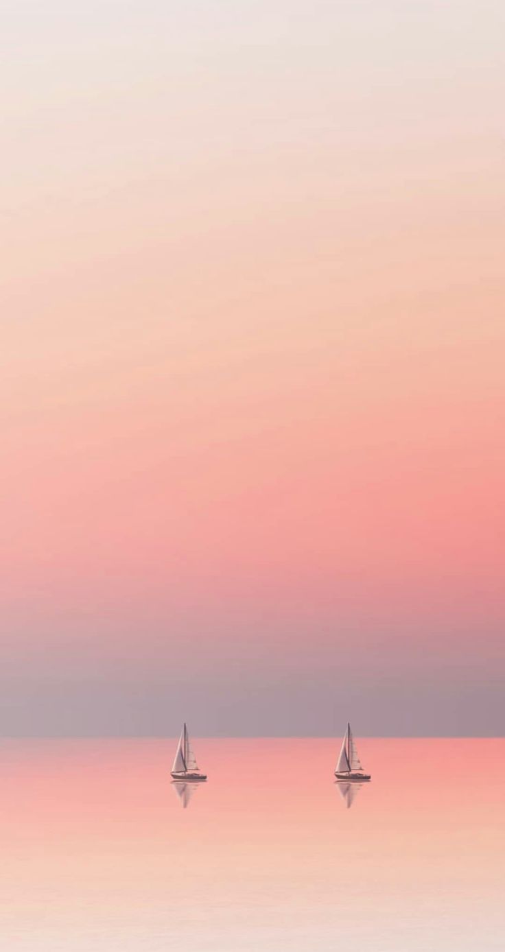 three sailboats floating in the water at sunset or dawn with pink and blue sky