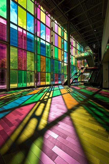 the sun shines through colorful windows in an empty building