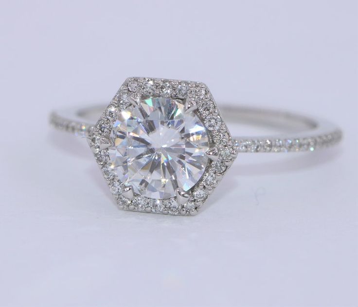 an engagement ring with a diamond center surrounded by pave diamonds