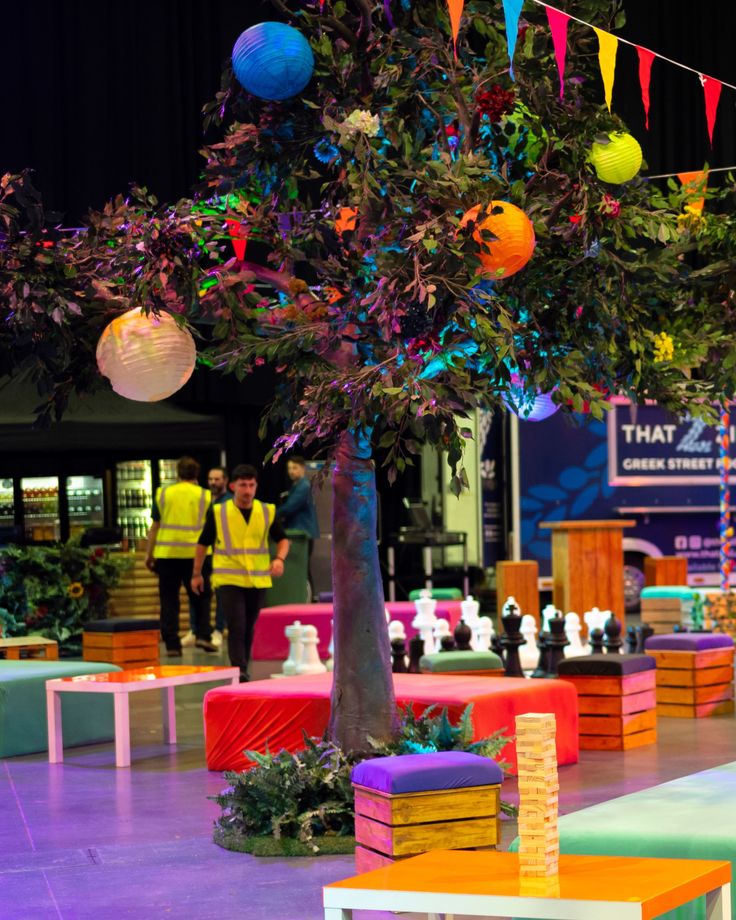 a tree that is sitting in the middle of a room with colorful decorations on it