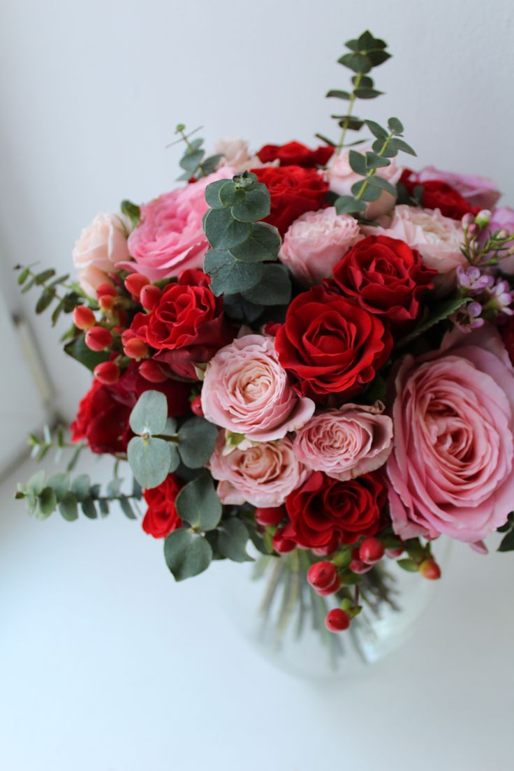 a vase filled with red and pink flowers