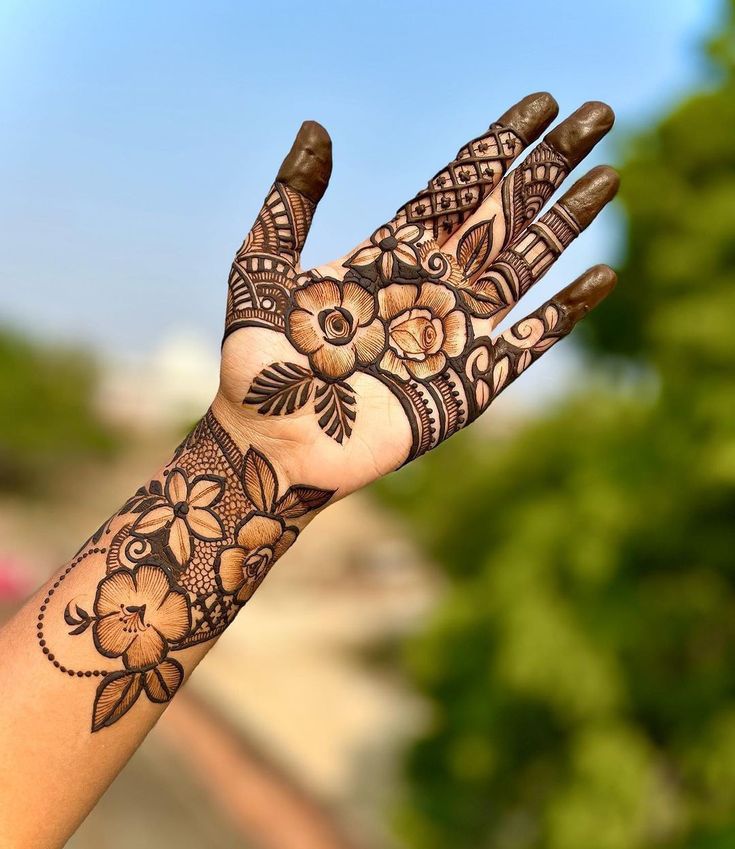 a woman's hand with henna tattoos on it