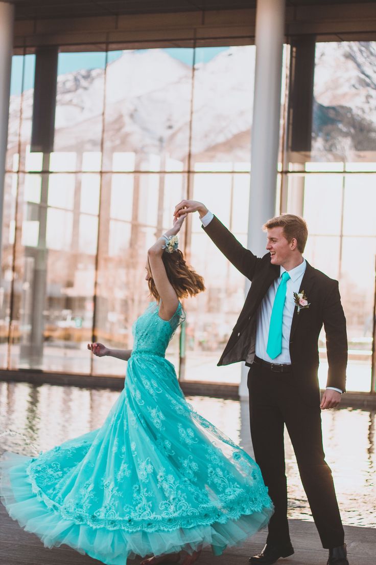 a man and woman in formal wear dancing