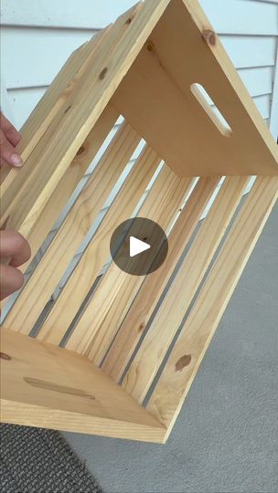 someone is holding a wooden birdhouse with the bottom section cut out to show how it's built