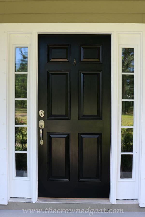 a black front door with white trim and two sidelights on the outside of it