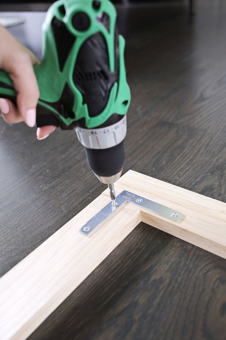 a person using a drill to cut out a piece of wood with a machine on it