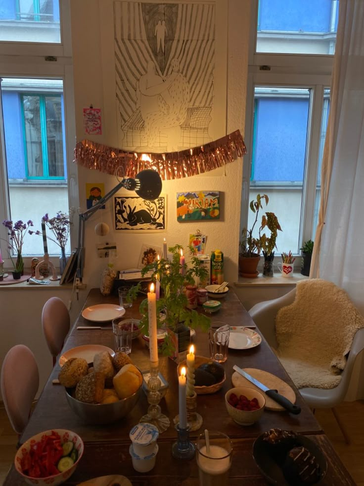 a dining room table is set with food and candles