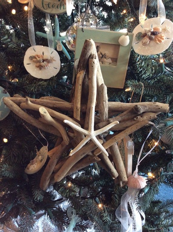 an ornament made out of driftwood sticks is hanging on a christmas tree