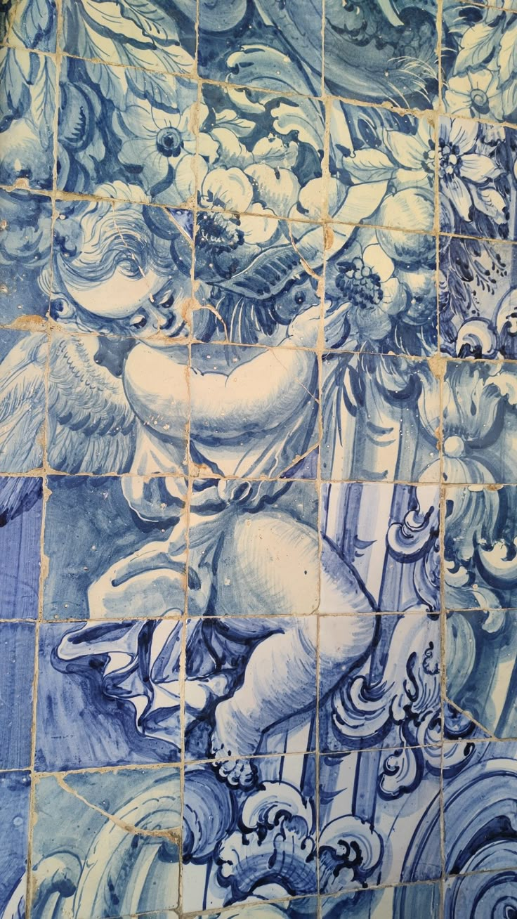 a blue and white tiled wall with an artistic painting on it