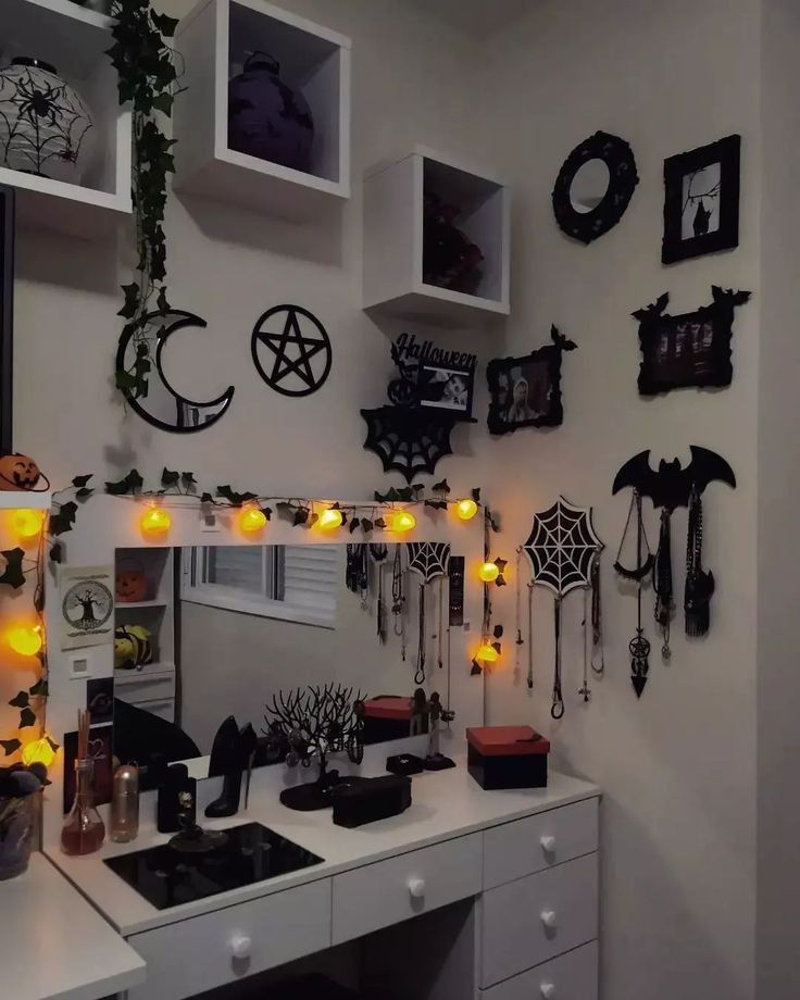 a white desk topped with lots of halloween decorations and decorating items on top of it