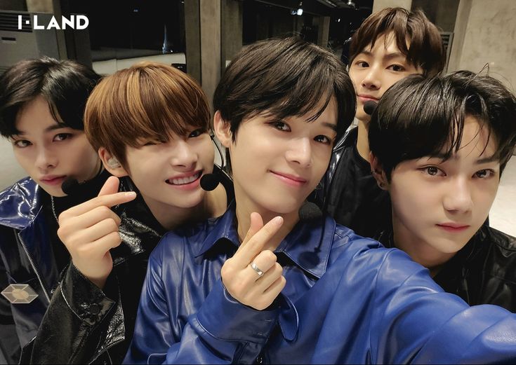 four young men posing for the camera in front of a mirror with their fingers up