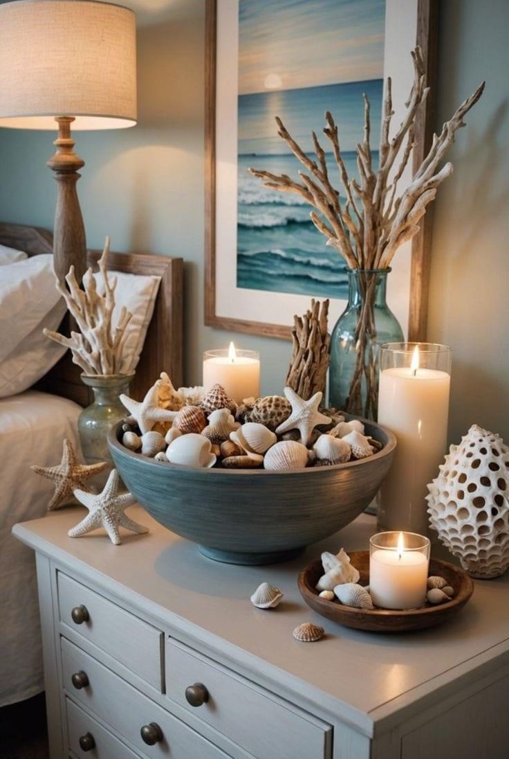 a bowl filled with seashells and candles on top of a dresser next to a bed