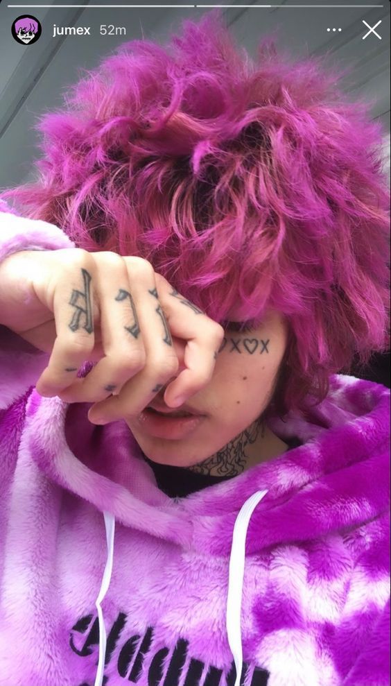 a woman with pink hair and tattoos covering her eyes