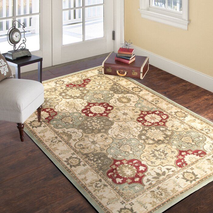 a living room area with a rug, chair and window sill on the floor