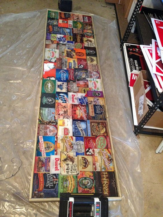 there is a long table made out of beer cans and soda cans on the floor