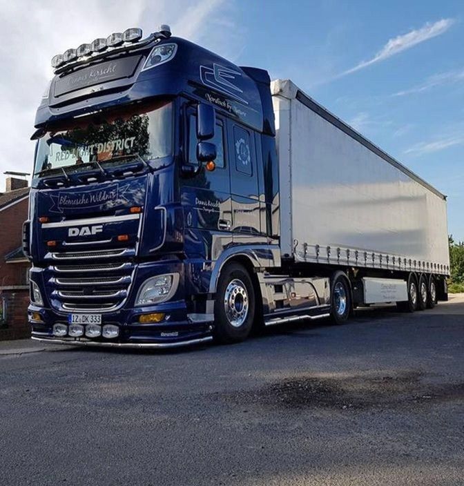 a blue semi truck parked in a parking lot