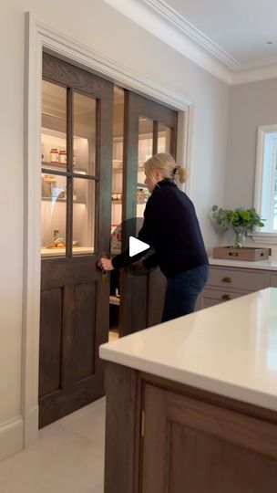 a woman opening the door to a kitchen