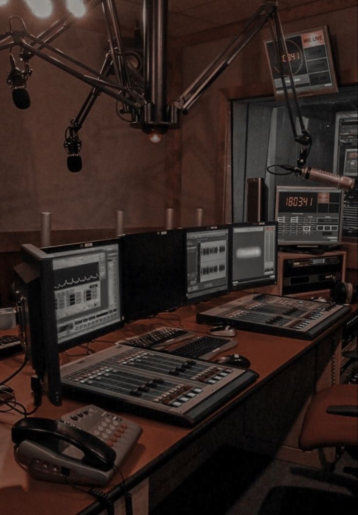 a recording studio with multiple monitors and microphones