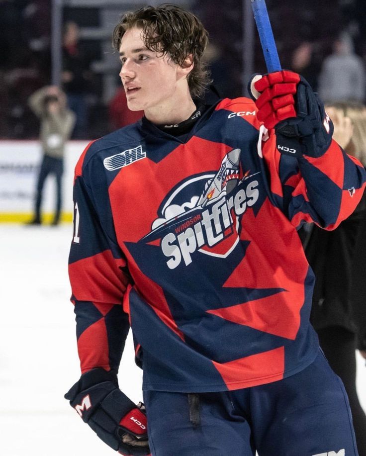 a young man holding up a hockey stick