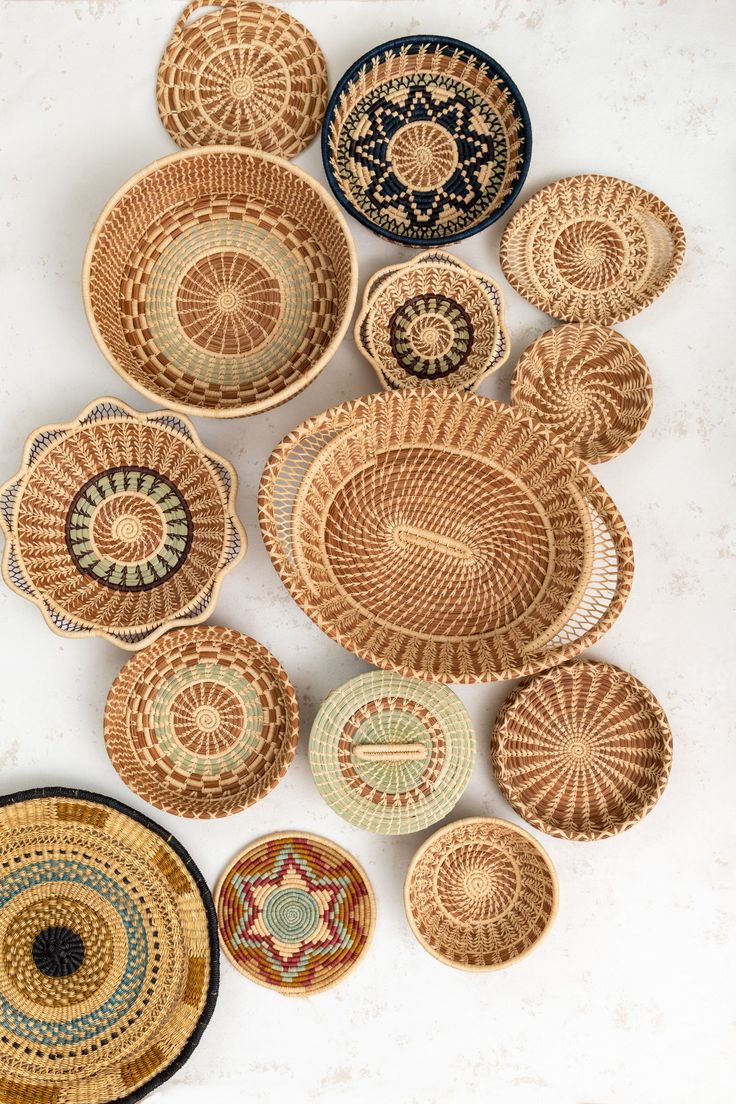 several woven baskets are arranged on a white surface