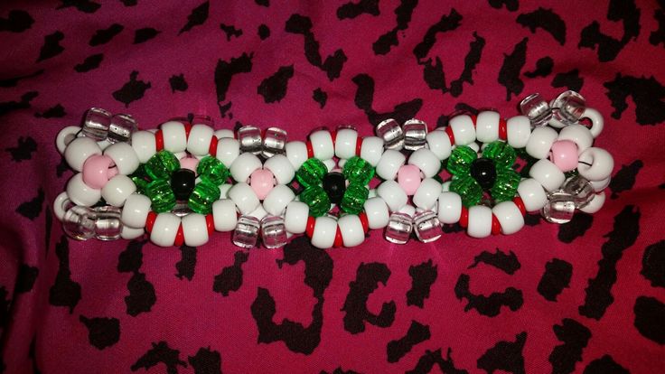 the beaded bracelet is decorated with candy canes and green leaves on pink leopard print fabric