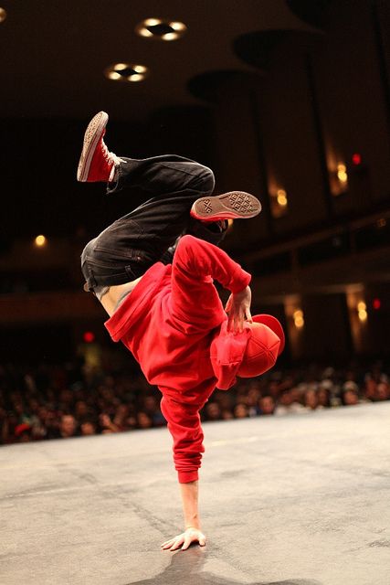 a man doing a trick with a frisbee in his hand while standing on one leg