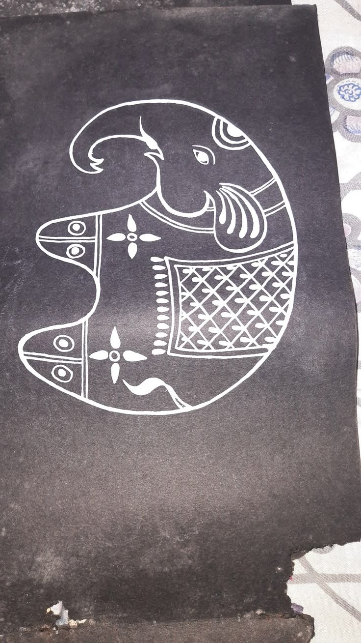 a black piece of paper with an elephant drawn on it