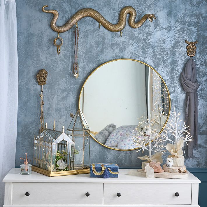 a white dresser topped with a mirror and a snake on it's sideboard