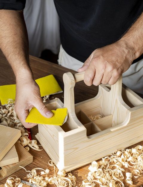 a man is sanding wood with yellow sponges