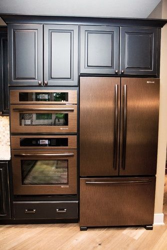 a kitchen with black cabinets and stainless steel appliances