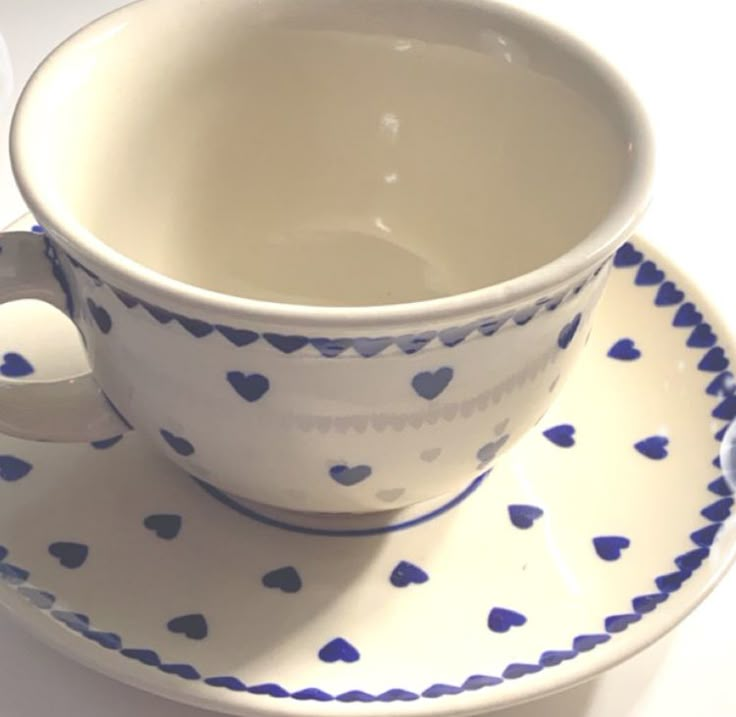 a cup and saucer with hearts on it