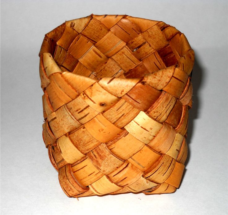 a woven wooden basket sitting on top of a table