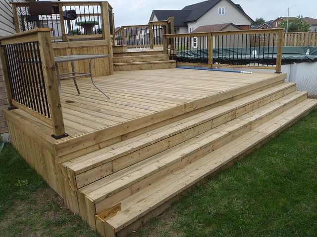 a large wooden deck with railings and steps