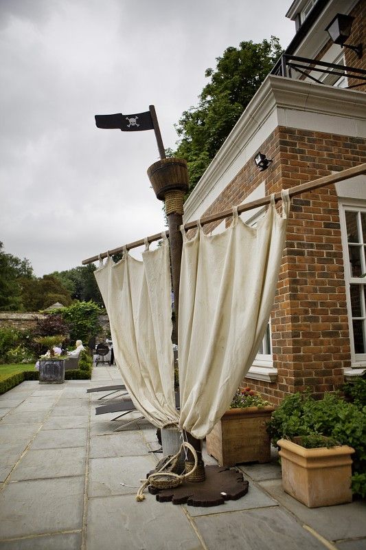 an old fashioned lamp post with curtains hanging from it