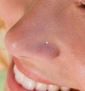 a close up of a woman's nose with a tiny piercing on her nose